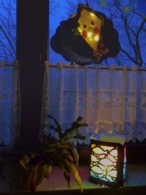 Martinslaterne in Fenster eines Wohnraums vor dunkler Außenansicht
