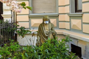 Statue mit Mundschutz in einem Vorgarten