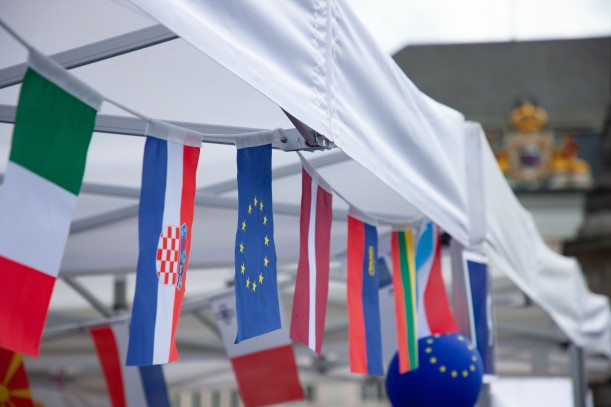 Girlande mit verschiedenen Nationalflagen und eine Luftballon mit Europasymbol an einem Pavillon