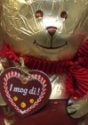In goldfarbene Folie verpackte Schokoladenbären mit roter Schleife, Lederhosenoptik und Herz mit der Aufschrift I mog di!