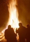 Menschen stehen im Dunkeln um ein brennendes Osterfeuer