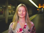 Porträt einer Frau mit geschlossenen Augen in einer U-Bahnstation