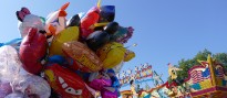 Bunte Luftballons vor einem Fahrgeschäft auf dem Jahrmarkt
