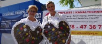 Zwei Frauen auf dem Jahrmarkt haben sich große Lebenkuchenherzen umgehängt