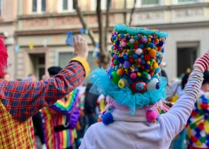 Zwei Menschen jubeln einem Karnevalswagen zu.