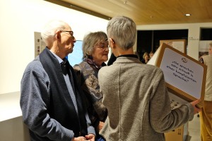 Drei Ausstellungsgäste halten einen Karton des Ausstllungsspiels.