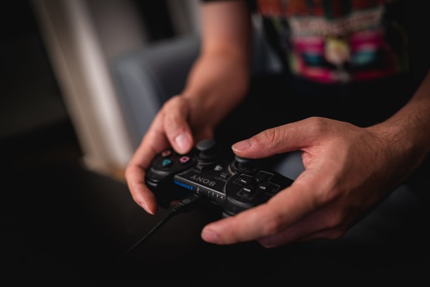 Ein in Händen gehaltener Playstation-Controller.