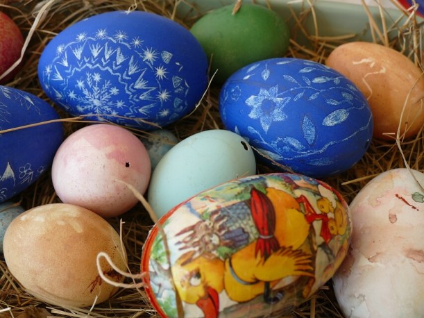 Verschiedenartig bemalte und verzierte Eier in einem Osternest. Drei blau bemalte Gänseeier sind mit Blumenmustern und Ornamenten in der Kratztechnik verziert.