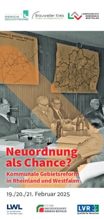 NRW Minister am Tisch vor Karten des Neugliederungsgebiets