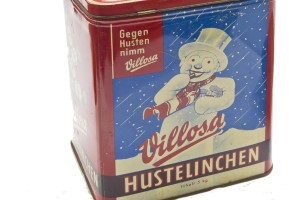 Abbildung einer Dose in roter Grundfarbe mit der Aufschrift „Gegen Husten nimm Villosa – Hustelinchen“ und einem gemalten lächelnden Schneemann.