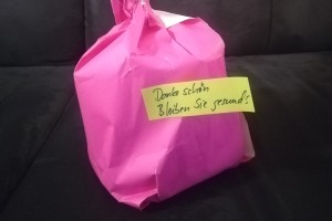 Foto: Geschenk in rosafarbenes Papier verpackt mit einem Zettel "Dankeschön. Bleiben Sie gesund"
