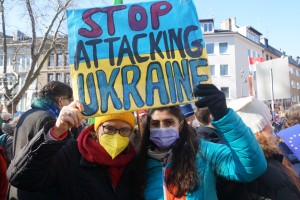 Zwei Frauen mit einem Schild: Stop Attacking Ukraine