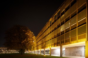Orange angestrahltes Bürogebäude im Baustil der 1950er Jahre vor Nachthimmel