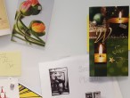 Verschiedene Postkarten und Zettel hängen an einem Whiteboard. 