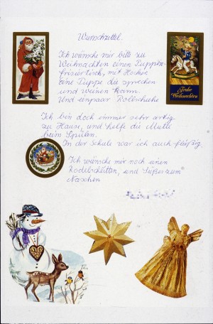 Wunschzettel eines Mädchens, beklebt mit unterschiedlichen Motiven: Weihnachtsmann, Schlitten mit Geschenken, Engel, Stern, Schneemann.