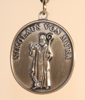 Anhänger aus Metall mit einer Darstellung von Nikolaus von Myra. Über der Abbildung steht am Rand entlang sein Name.