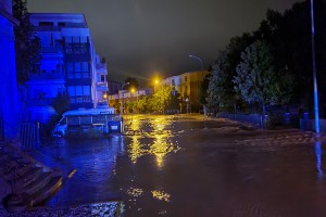 Die Euskirchener Innenstadt unter Wasser. Eine Nachtaufnahme mit blauen und gelben Lichtern zeigt das Hochwasser.