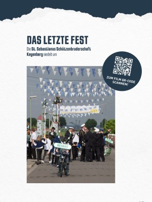 Schützenzug in geschmückter Straße, im Hintergrund ist ein Bagger des Tagebaus zu erkennen.