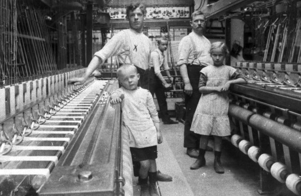 Kinder und Arbeiter*innen in der Bandweberei, um 1910.