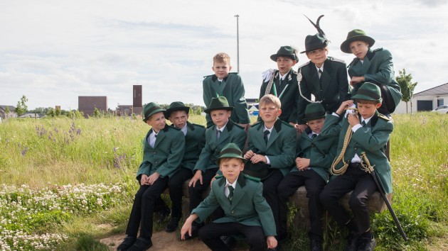 Elf Jungen in Schützenuniform haben sich für ein Gruppenfoto positioniert.