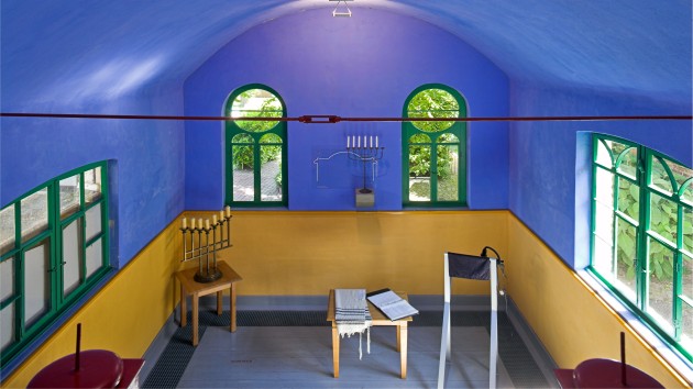 Der Synagogenraum mit zwei Leuchtern (Menora).