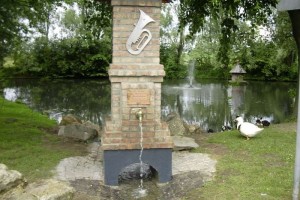 Brunnen mit einer Trompete verziert an einem Weier